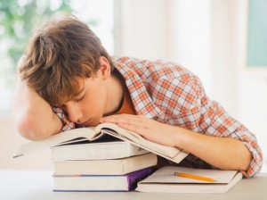 Teenage boy (14-15) sleeping in classroom